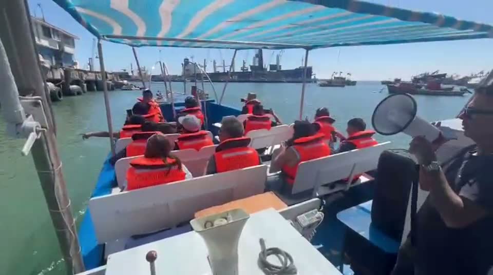Pasajeros con chaleco salvavidas zarpando del puerto de Arica